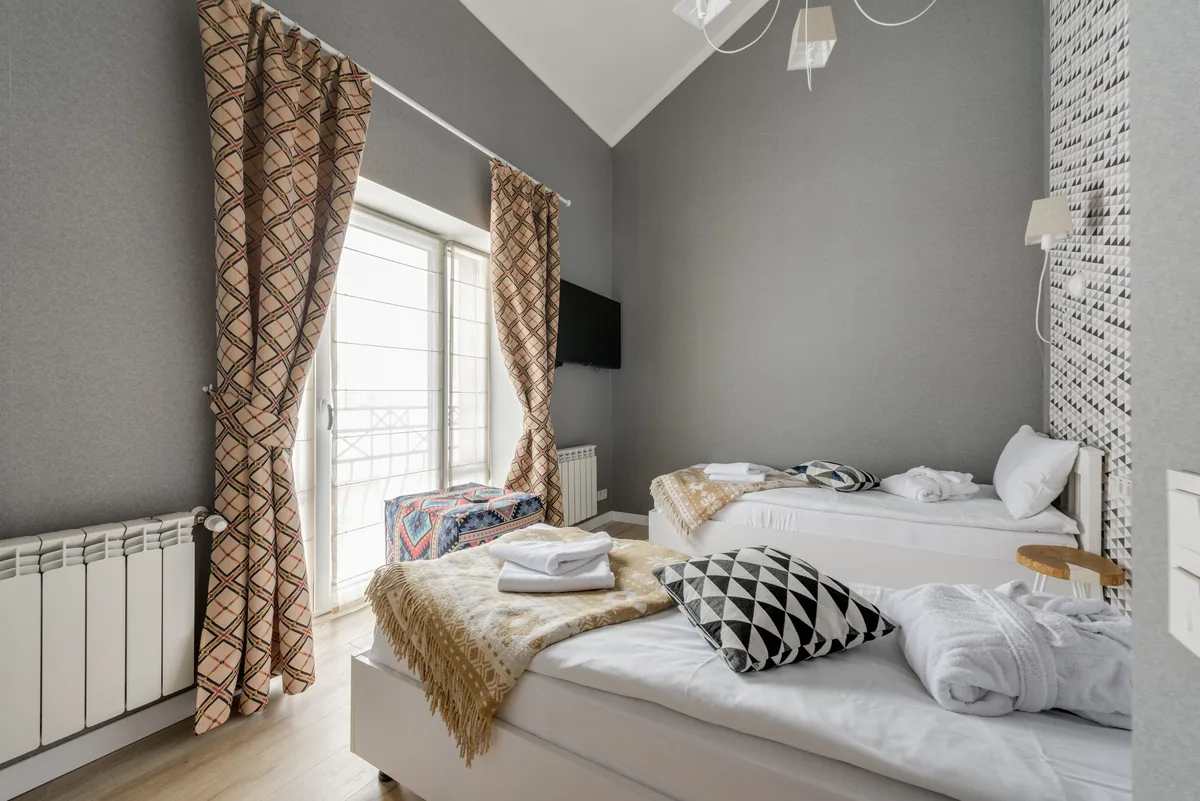 A bedroom made up for arrival, with towels and robes laid out