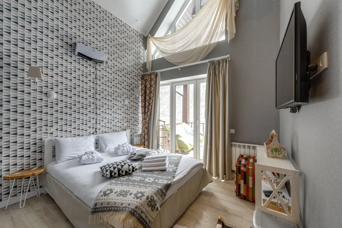 A short-let bedroom with folded towels at the foot of the bed