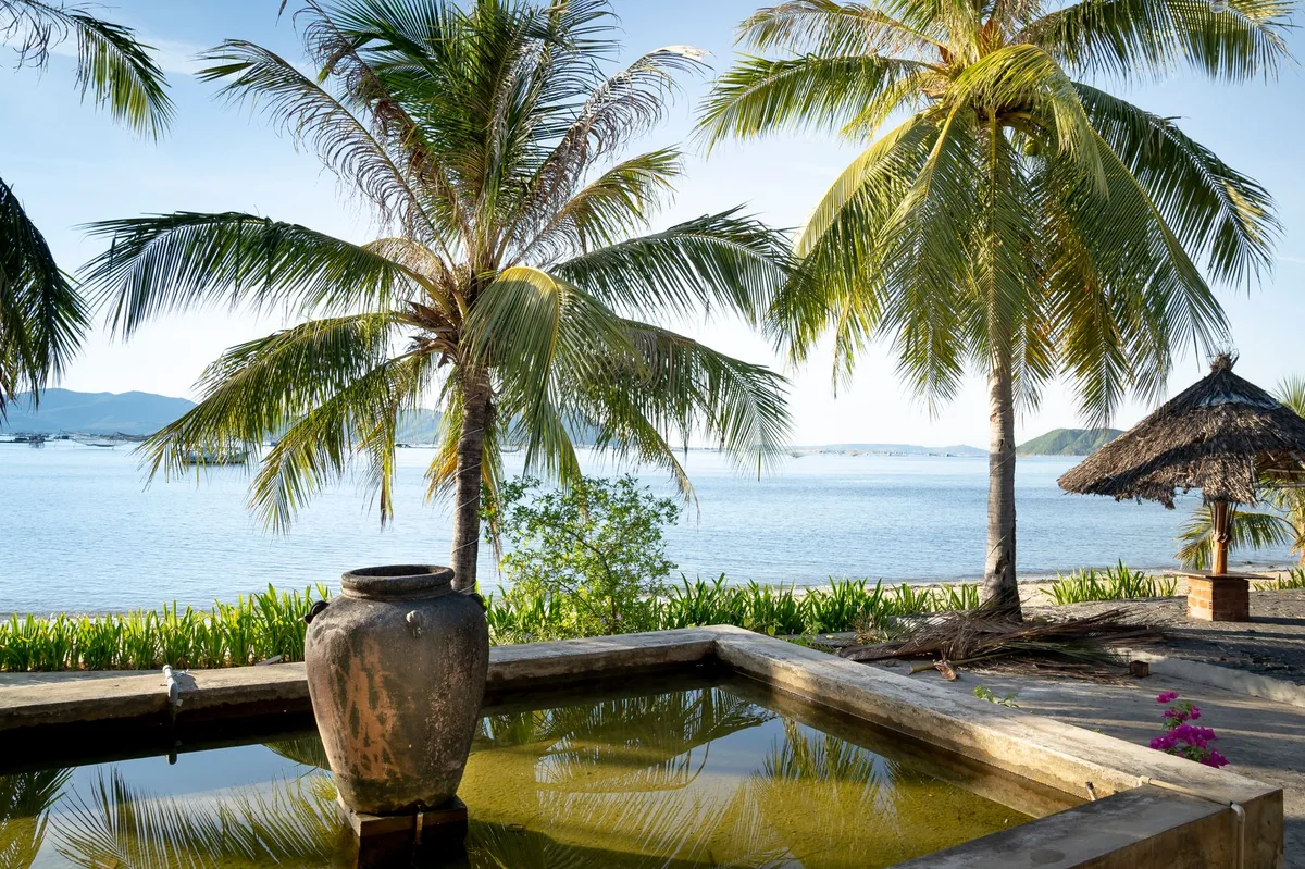 Thailand rental villa management, water feature and palms overlooking the sea
