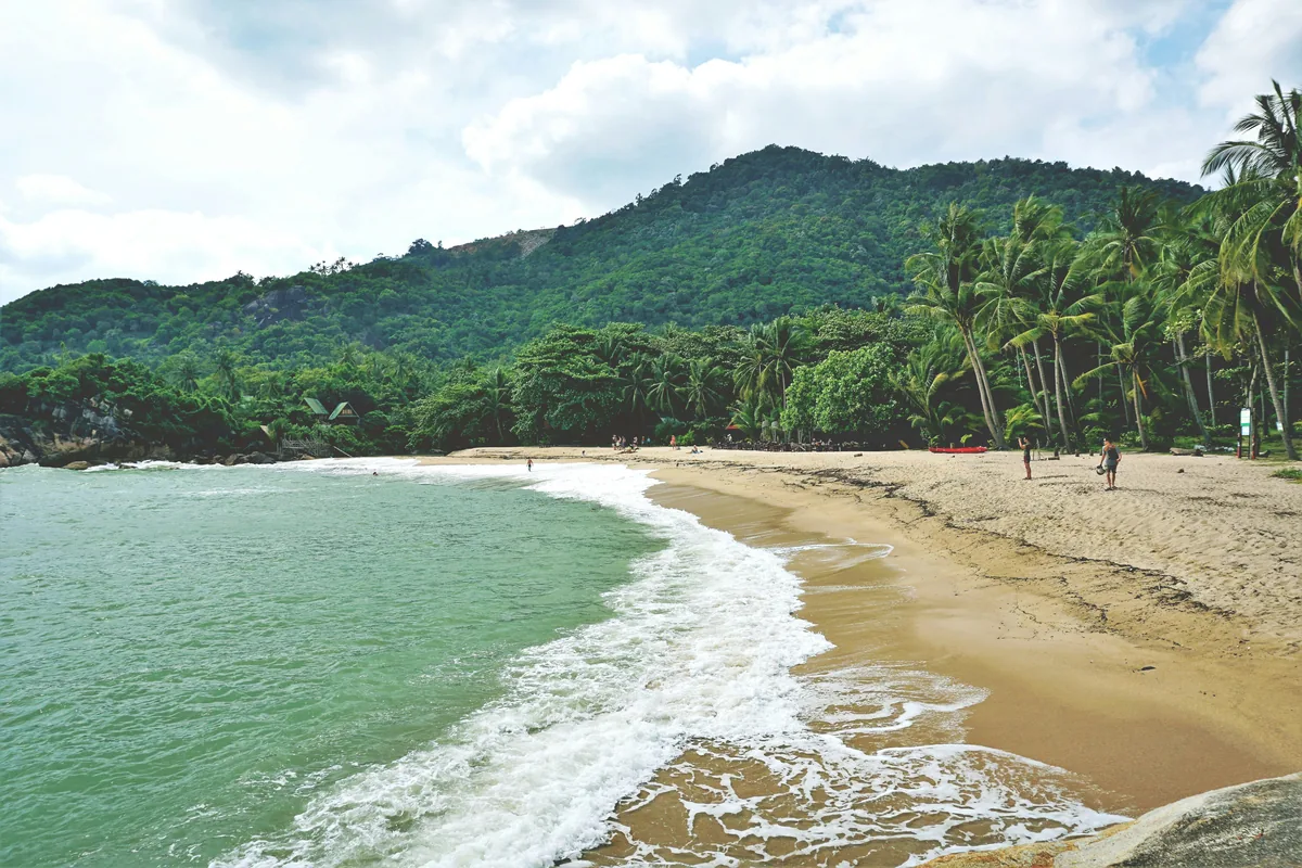 Koh Phangan villa management, a curved bay under a forested headland