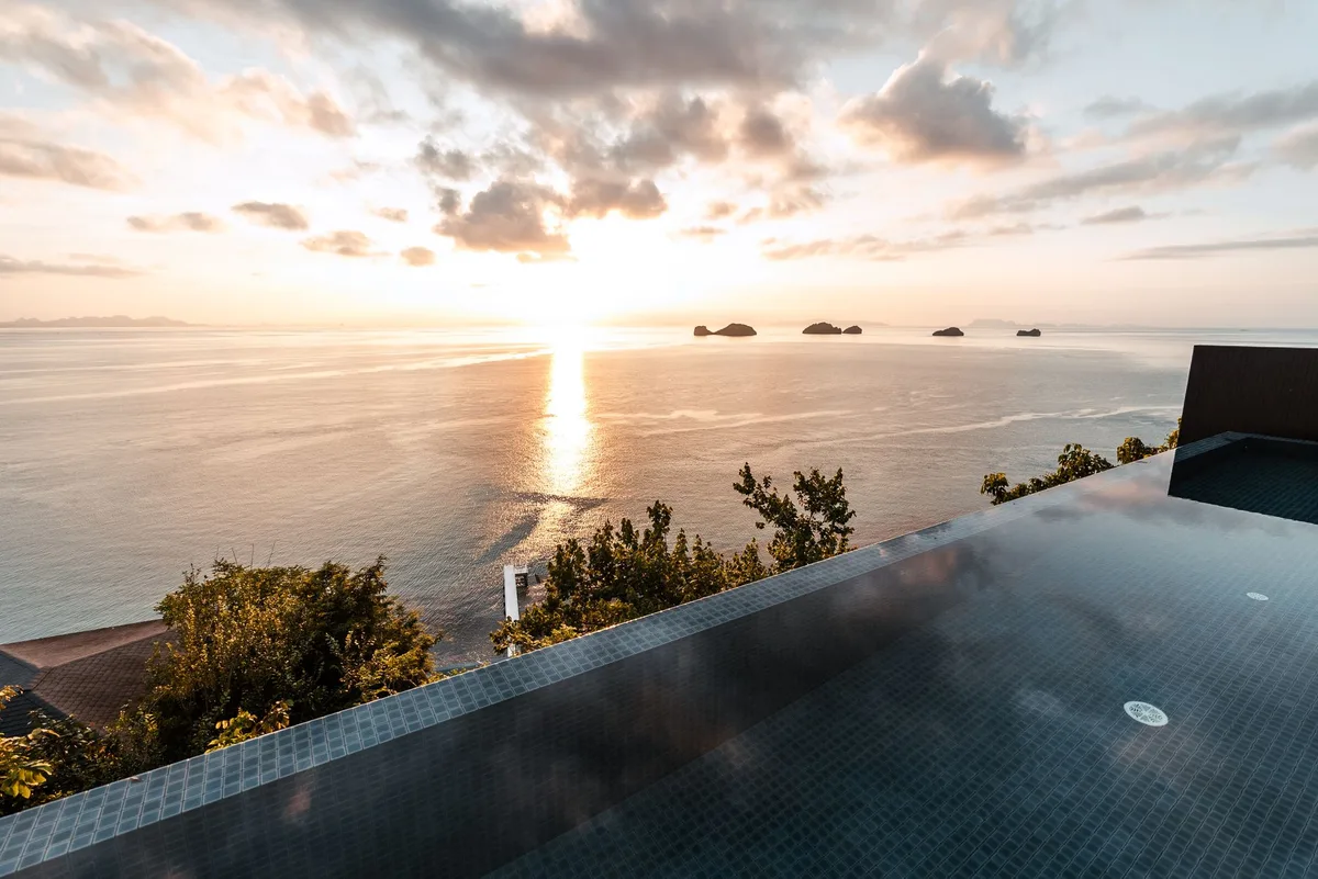 Koh Samui property management, infinity pool at sunset overlooking offshore islands