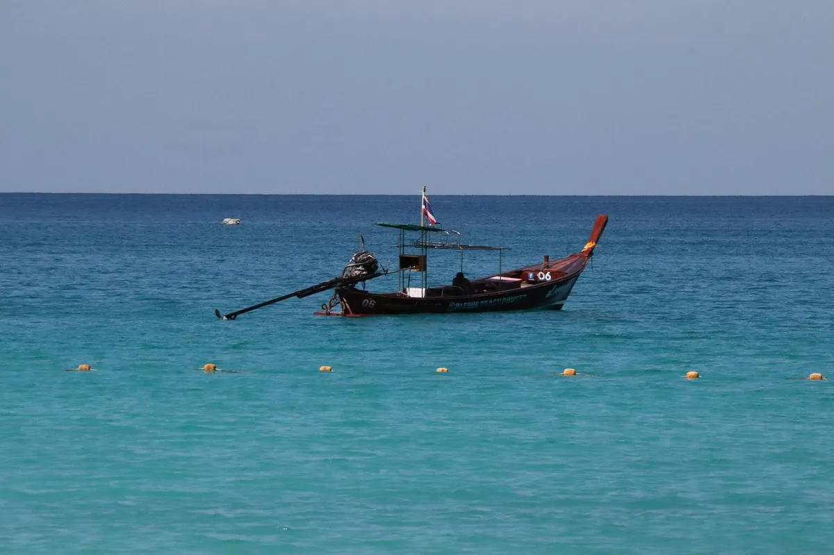 A longtail boat moored on clear turquoise water