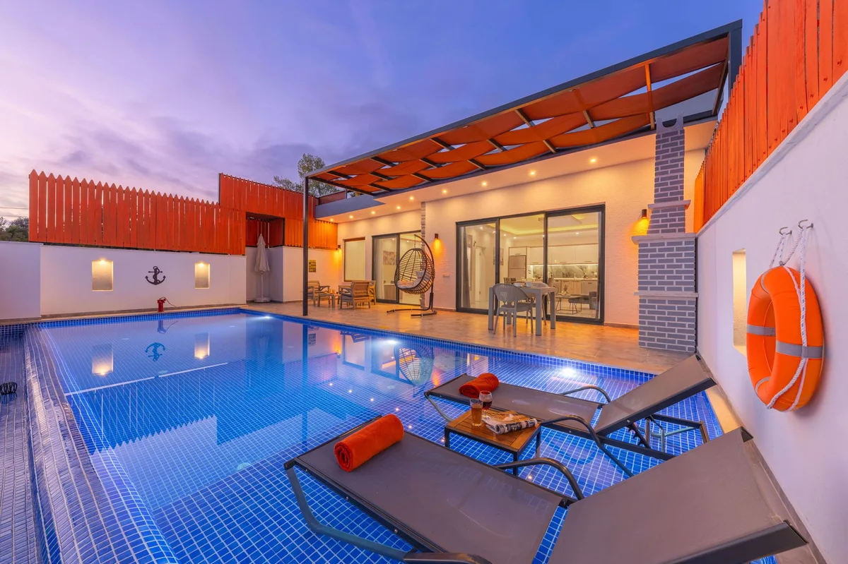 Villa rental management, pool and loungers beside a modern villa