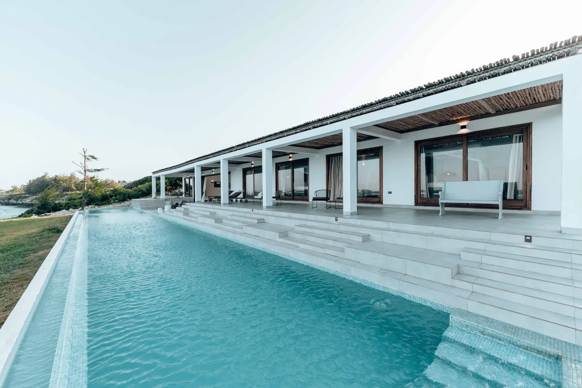 A modern single-storey villa with a long lap pool along its terrace