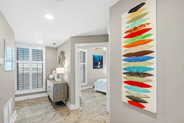 Hallway with coastal artwork and a bedroom doorway in our Gulf Shores rental