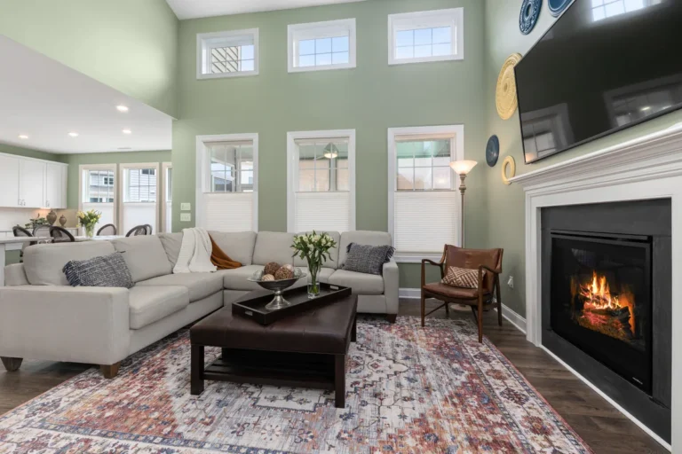Living room with a fireplace, a grey sectional and green walls