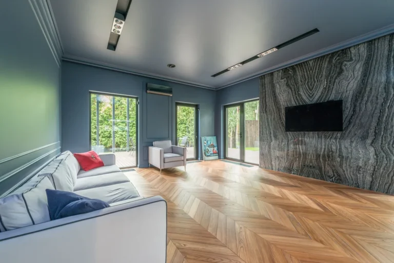 Living room with a marble feature wall, sofa and wooden flooring