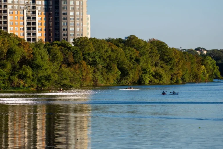 Kayakers on Lady Bird Lake next to Austin apartment buildings