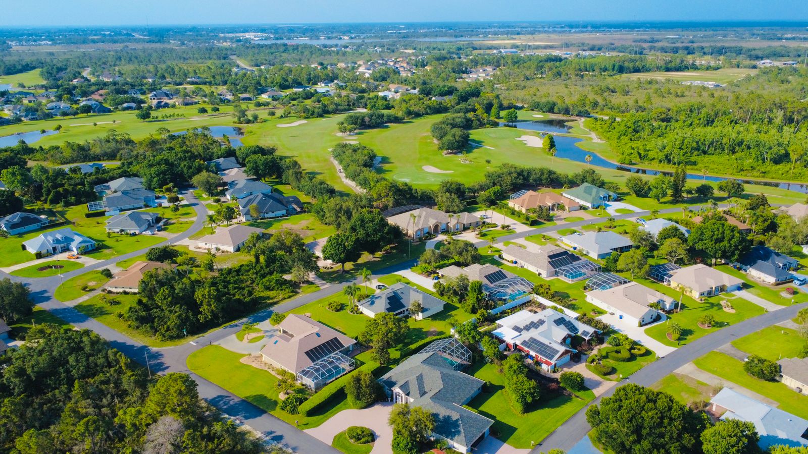 Aerial view of a suburban neighborhood with green lawns and trees