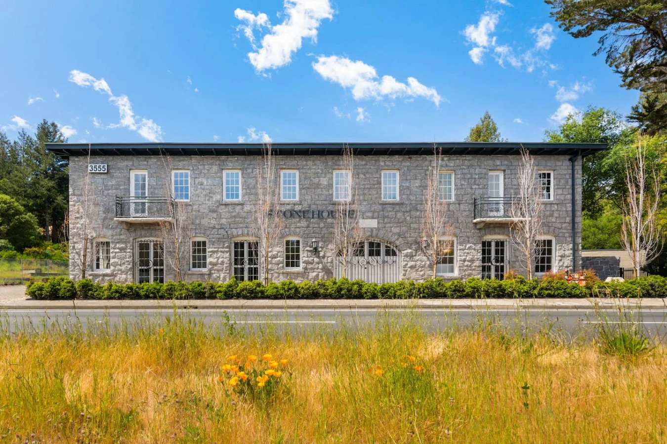 Two-storey stone building behind a meadow in Santa Rosa