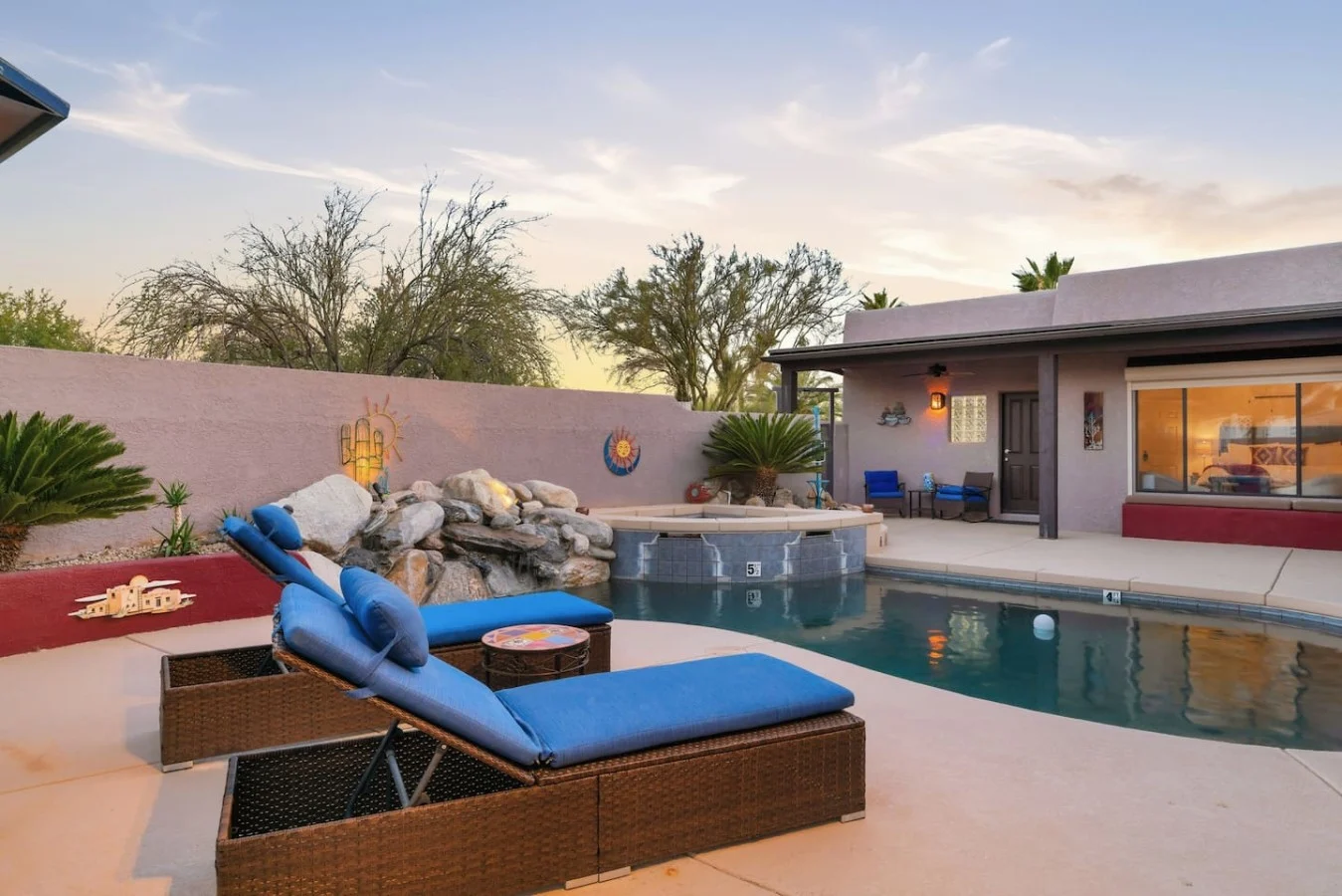 Pool, hot tub and loungers on a patio with desert mountains in Tucson