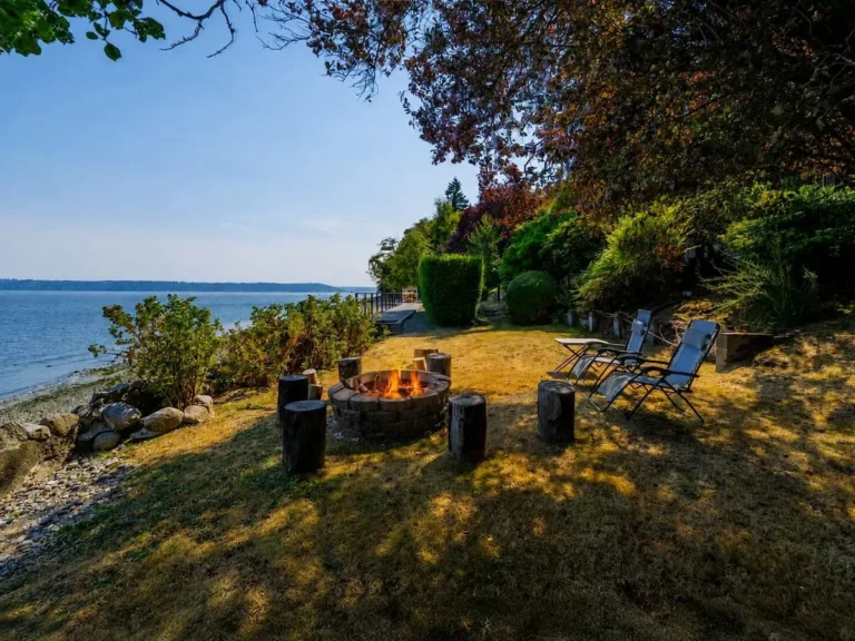 Waterfront garden with a fire pit and chairs at our Vashon home