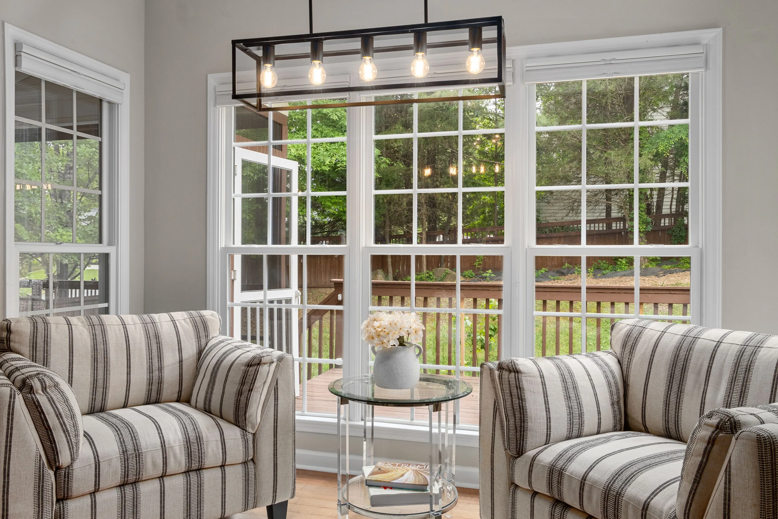 Bright living room with striped armchairs and large garden windows
